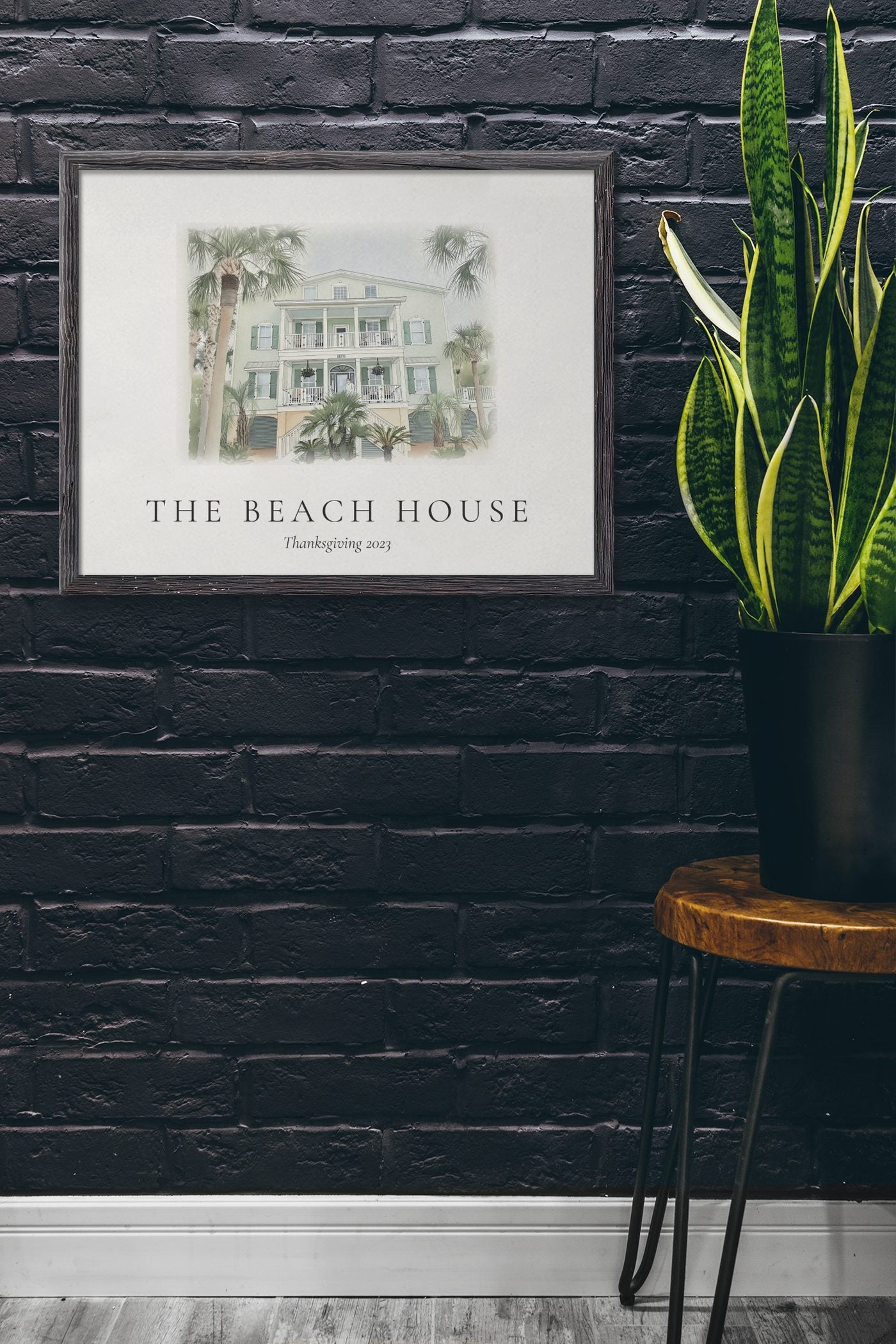 An ink and wash illustration of the Beach House, framed on a dark brick entryway wall.