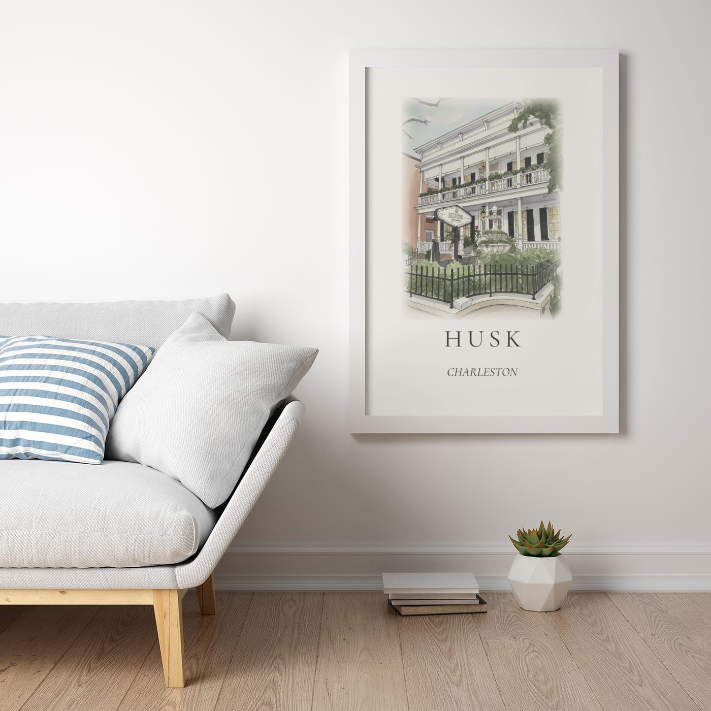 An ink and wash illustration of Husk restaurant, framed above a linen sofa in a bright minimalist living room.